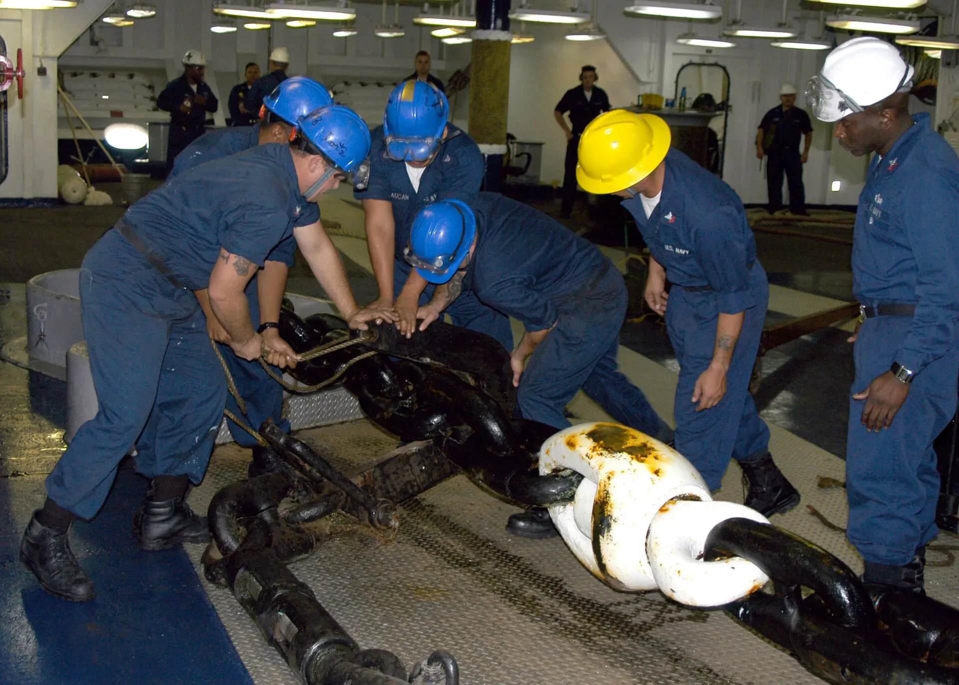 Deck crew working together on an anchor chain