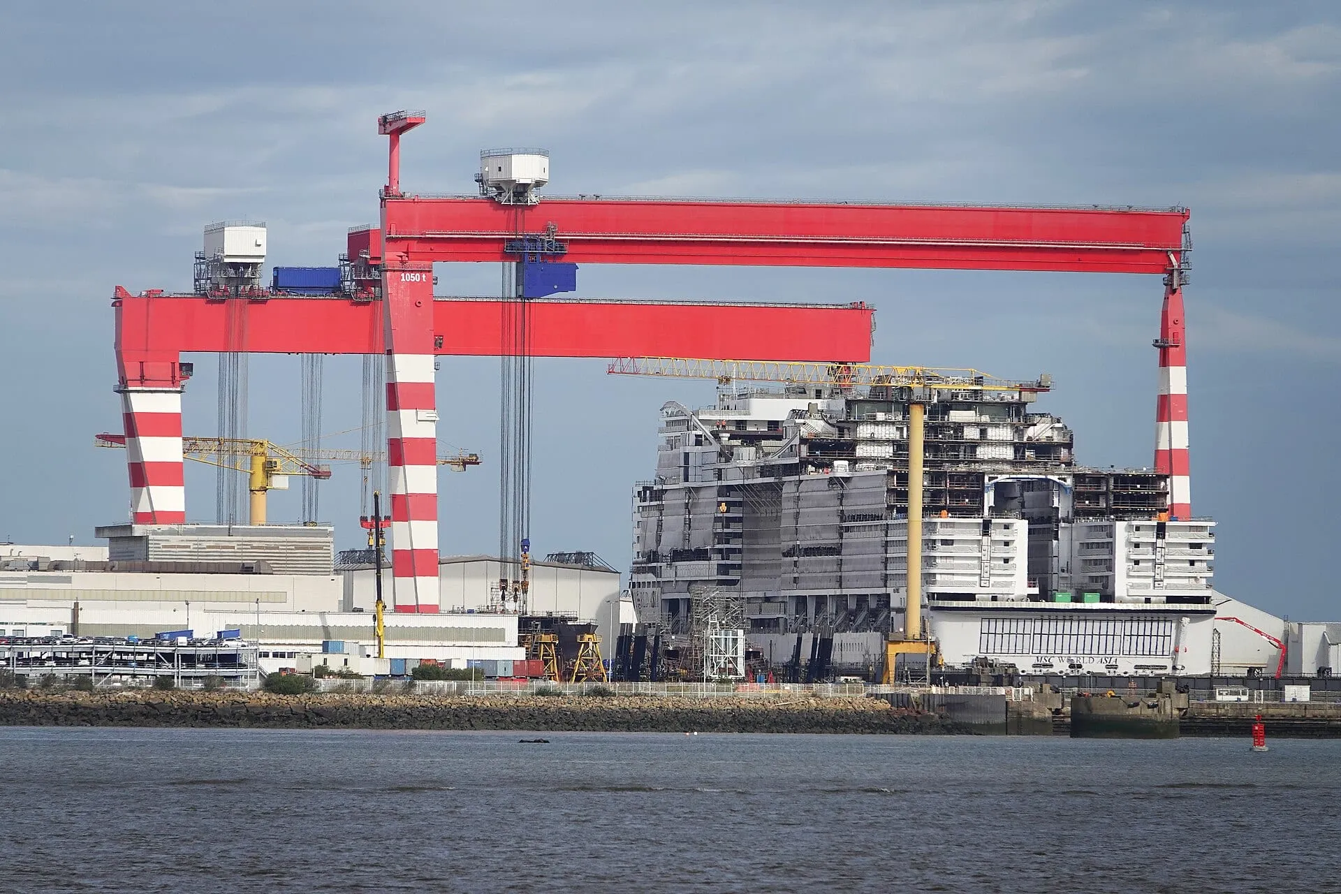 Gantry crane lifting a hull block at a shipyard