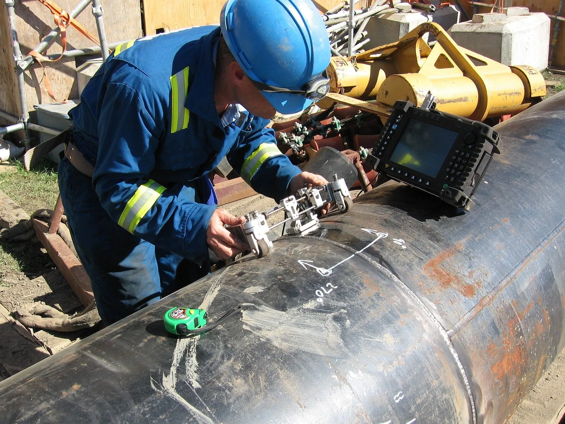 Technician scanning a pipeline weld with test equipment